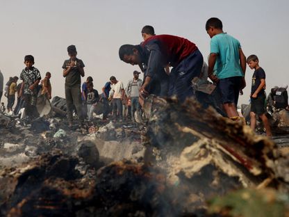 فلسطينيون أمام خيام محترقة بعد غارة إسرائيلية استهدفت المنطقة التي نزح إليها فلسطينيون في رفح. 27 مايو 2024 - AFP