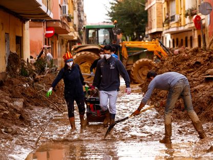 متطوعون يقومون بإزالة الطين من أحد الشوارع في أعقاب الفيضانات الناجمة عن الأمطار الغزيرة في فالنسيا بإسبانيا. 3 نوفمبر 2024 - Reuters