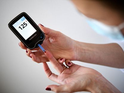 امرأة مصابة بداء السكري تستخدم جهازاً لقياس نسبة سكر الدم في باريس. 24 مارس 2020 - AFP