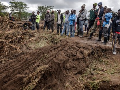 أشخاص يقفون على قمة منطقة تضررت من الانهيارات الأرضية في أعقاب الأمطار الغزيرة والفيضانات المفاجئة في ماي ماهيو بكينيا. 30 أبريل 2024 - AFP