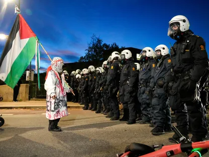 متظاهرة تحمل العلم الفلسطيني تقف أمام عناصر من الشرطة خارج ملعب أوليفال خلال مباراة النرويج وإسرائيل في تصفيات كأس العلم لكرة القدم في أوسلو. 11 أكتوبر 2025 - Reuters
