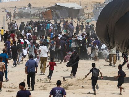 فلسطينيون يركضون نحو المساعدات التي جرى إسقاطها جواً، في دير البلح، وسط قطاع غزة. 19 أغسطس 2025 - REUTERS