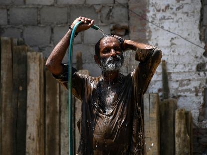 رجل يبرد جسده بخرطوم مياه خلال يوم صيفي حار في حيدر أباد بباكستان. 24 مايو 2024 - REUTERS