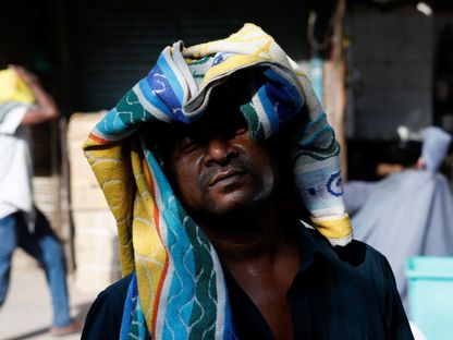 رجل يستخدم منشفة لحماية رأسه من الحرارة في يوم صيفي حار في نيودلهي، الهند، 28 مايو 2024 - REUTERS
