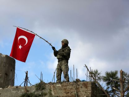 جندي تركي يلوح بعلم بلاده شمال شرق عفرين في سوريا- 28 يناير 2018 - REUTERS