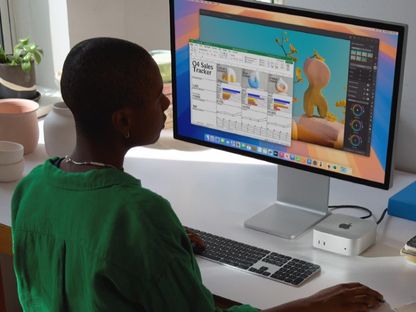 صورة غير مؤرخة لشخص يجلس أمام جهاز أبل ماك ميني - Apple