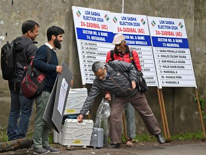 مسؤولو الاقتراع الكشميريون يحملون آلات التصويت الإلكترونية (EVM) قبل المرحلة الرابعة من التصويت على الانتخابات العامة الهندية في سريناجار. 12 مايو 2024. - AFP
