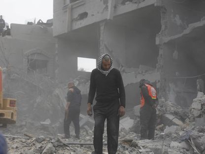عمليات بحث وإنقاذ للوصول إلى الجرحى والضحايا الفلسطينيين بعد أن استهدف الجيش الإسرائيلي مبنى تابع لعائلة فلسطينية في دير البلح بغزة. 23 فبراير 2024 - AFP