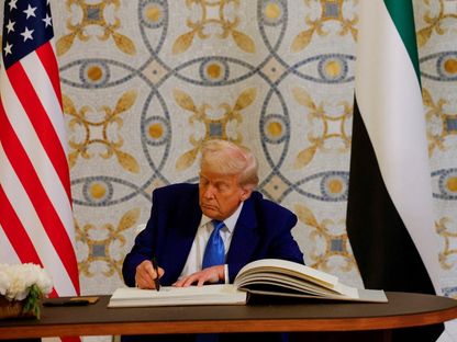 الرئيس الأميركي دونالد ترمب يوقع في دفتر ضيوف بجوار رئيس الإمارات الشيخ محمد بن زايد في قصر الوطن بالعاصمة أبو ظبي. 15 مايو 2025 - REUTERS