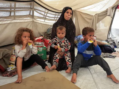 امرأة فلسطينية تجلس مع أطفالها في خيمة في مدينة غزة. 14 نوفمبر 2025 - REUTERS
