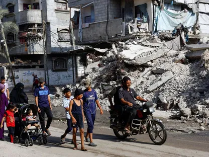 عائلات فلسطينية بجنوب قطاع غزة تمشي بالقرب من  أنقاض منازل دمرتها الغارات الإسرائيلية في أعقاب موافقة حركة "حماس" على خطة ترمب لإنهاء الحرب. 4 أكتوبر 2025 - REUTERS