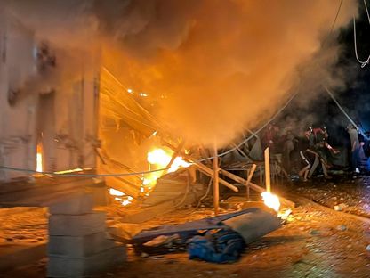 فلسطينيون يحاولون إنقاذ مصابين في موقع غارة إسرائيلية على مدرسة تابعة للأونروا تؤوي نازحين بمخيم البريج وسط غزة. 6 مايو 2025 - Reuters