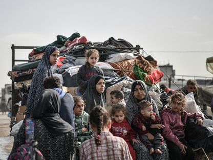 أفراد عائلة فلسطينية في طريقهم إلى رفح على أمل العثور على مكان أكثر أماناً بعد هجرتهم الحرب من مخيم النصيرات وسط هجمات إسرائيلية مكثفة على قطاع غزة. 23 ديسمبر 2023 - AFP