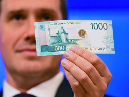 نائب حاكم المصرف المركزي الروسي سيرجي بيلوف يحمل ورقة نقدية جديدة من فئة ألف روبل بعد إعادة تصميمها، موسكو. 16 أكتوبر 2023 - AFP