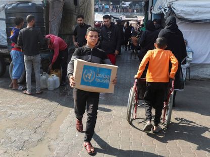 فلسطيني يحمل صندوق مساعدات وزعته وكالة "الأونروا" في دير البلح وسط قطاع غزة. 4 نوفمبر 2024 - REUTERS