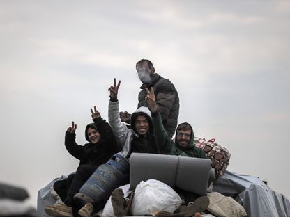 نازحون فلسطينيون يلوحون بعلامة النصر أثناء عبورهم محور نتساريم باتجاه شمال غزة بعد انسحاب القوات الإسرائيلية من وسط غزة. 10 فبراير 2025 - bloomberg