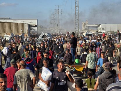 فلسطينيون يتجمعون في مركز توزيع المساعدات في دير البلح بقطاع غزة. 28 مايو 2025 - Reuters