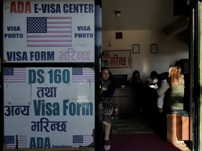 امرأة تقف قرب باب مكتب يساعد في تقديم نموذج طلب تأشيرة الولايات المتحدة في كاتماندو بنيبال. 28 نوفمبر 2025 - REUTERS