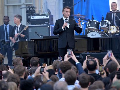 الرئيس الفرنسي إيمانويل ماكرون يتحدث خلال مهرجان الموسيقى السنوي Fete de la musique الذي يستمر ليوم واحد في فناء قصر الإليزيه الرئاسي في باريس. 21 يونيو 2024. - AFP