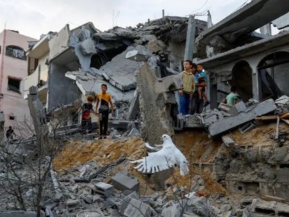 أطفال وسط أنقاض منازل دمرتها الغارات الإسرائيلية في خان يونس جنوب قطاع غزة. 11 أكتوبر 2023 - Reuters