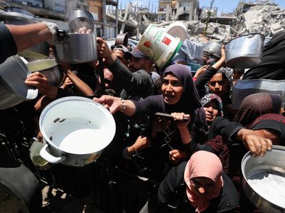 فلسطينيون ينتظرون الحصول على طعام من مطبخ خيري في بيت لاهيا بشمالي قطاع غزة. 8 مايو 2025 - REUTERS