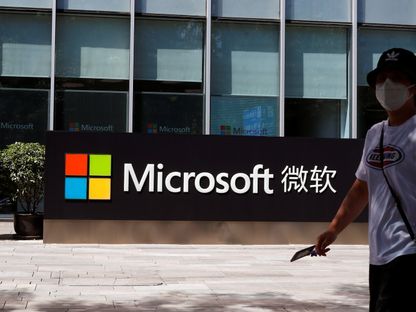 صينية تمر أمام شعار مايكروسوفت في مكتب الشركة بالعاصمة بكين. 4 أغسطس 2020 - REUTERS