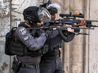 قوات الأمن الإسرائيلية تصوب أسلحتها خلال اشتباكات مع فلسطينيين في مخيم شعفاط بالقدس الشرقية. 25 يناير 2023 - AFP