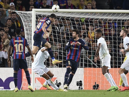 روبرت ليفاندوفسكي مهاجم برشلونة يوجه الكرة برأسه مسجلاً هدف التعادل في شباك إنتر ميلان - 12 أكتوبر 2022 - AFP