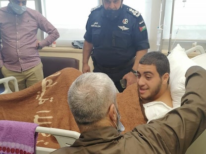 والد الضحية في "جريمة الزرقاء" خلال زيارته ابنه صالح في المستشفى - الأمن العام الأردني