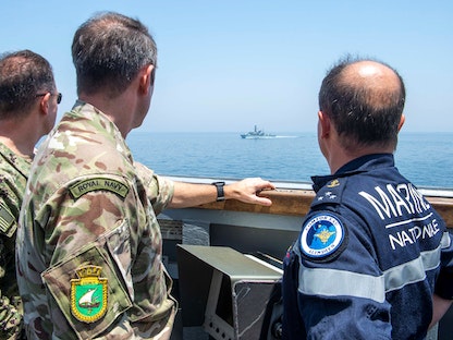 ضباط أميركيون وبريطانيون يراقبون قطعة بحرية حربية تعبر مضيق هرمز. 19 مايو 2023 - REUTERS