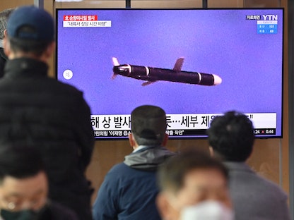 يشاهدون شاشة تعرض لقطات لإطلاق صاروخ كوري شمالي في محطة قطارات في سيول عاصمة كوريا الجنوبية. 25 يناير 2022. - AFP
