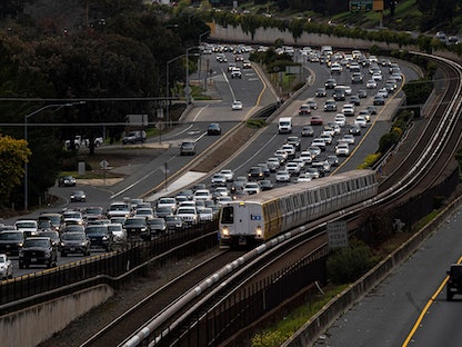 قطار نقل وسيارات على طريق سريع في كاليفورنيا - 17 مارس 2021 - Bloomberg