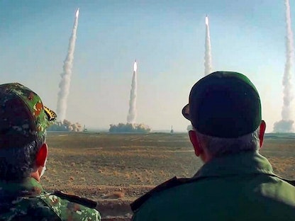 رئيس الحرس الثوري الإيراني حسين سلامي (يمين) يشاهد إطلاق صواريخ أثناء مناورة عسكرية في موقع غير محدد بوسط إيران. 15 يناير 2021 - AFP
