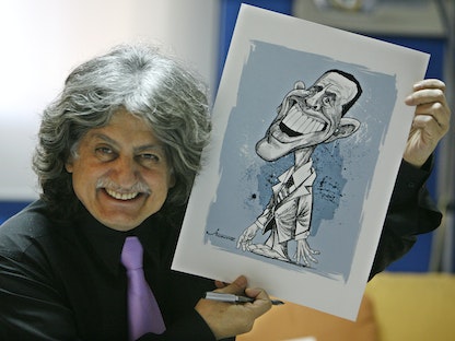 ستافرو جبرا يعرض إحدى رسومه الكاريكاتورية التي تصور الرئيس الأميركي الأسبق باراك أوباما بورشته في بيروت- 5 نوفمبر 2008. - REUTERS