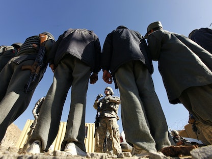جندي أميركي يتحدث إلى رجال أمن أفغان قبل الذهاب في مهمة بمقاطعة خوست - أفغانستان - 23 ديسمبر 2009 - REUTERS