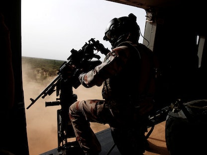جندي فرنسي يصوّب مدفعاً رشاشاُ من مروحية عسكرية خلال عملية برخان فوق نداكي، مالي - 29 يوليو 2019 - REUTERS