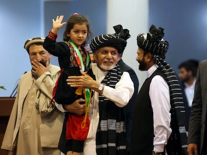 أشرف غني يحمل فتاة خلال تجمّع انتخابي في كابول - 13 سبتمبر 2019 - REUTERS