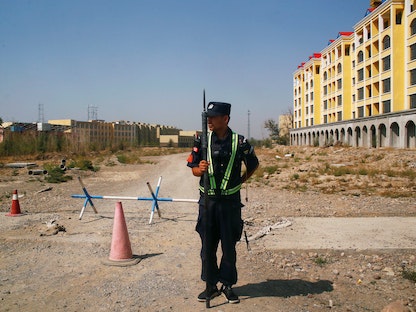 شرطي صيني يحرس الطريق بالقرب مما يطلق عليه رسمياً "مركز التعليم المهني" في مدينة ينينغ الصينية. في 9 ديسمبر 2020 - REUTERS