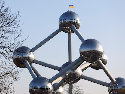 علم أوكرانيا فوق مجسم "أتوميوم" في بروكسل، حيث يوجد مقر الاتحاد الأوروبي. مارس 2022.  - REUTERS