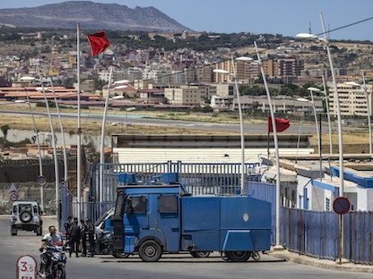 قوات الأمن المغربية تقف حراسة عند السياج الحدودي الذي يفصل المغرب عن جيب مليلية بالقرب من الناظور- 25 يونيو 2022. - AFP