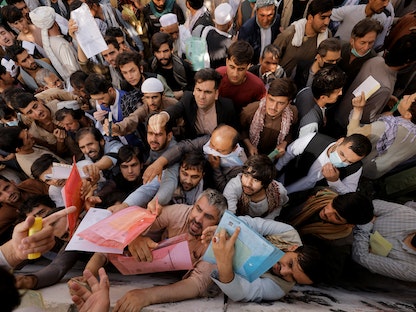أفغان يتجمعون خارج مكتب الجوازات بعد أن أعلن مسؤولو طالبان أنهم سيبدأون في إصدار جوازات سفر لمواطنيهم مرة أخرى بعد شهور من التأخير، أفغانستان. 6 أكتوبر 2021 - REUTERS