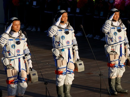 رواد فضاء صينيون يحيون الجماهير قبل إقلاعهم في رحلة مأهولة نحو مطة الفضاء الصينية. 17 يونيو 2021 - REUTERS