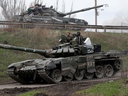 جنود من القوات الموالية لروسيا يقودون دبابات في الطريق إلى ماريوبل جنوب شرق أوكرانيا، 17 أبريل 2022 - REUTERS
