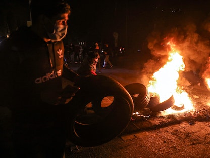 متظاهرون يشعلون النيران في الإطارات لقطع طريق بوسط بيروت- 2 مارس 2021 - AFP
