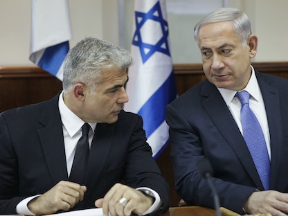 رئيس الوزراء الإسرائيلي الأسبق بنيامين نتنياهو ورئيس الوزراء الحالي يائير لبيد يحضران اجتماعاً للحكومة في القدس- 7 أكتوبر 2014  - REUTERS