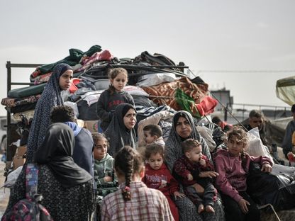 عائلة فلسطينية في طريقها إلى رفح على أمل العثور على مكان أكثر أماناً بعد النزوح من النصيرات بسبب القصف الإسرائيلي المكثف على قطاع غزة. 23 ديسمبر 2023- AFP - AFP