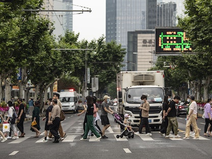 مشاة يعبرون الشارع في شنغهاي بعد تخفيف القيود على الحركة- 1 يونيو 2022 - Bloomberg