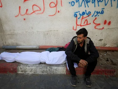 رجل فلسطيني يجلس بجوار جثمان أحد أفراد أسرته الذي قتلته غارات إسرائيلية على مدينة غزة. 20 نوفمبر 2025 - REUTERS