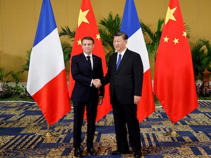 الرئيس الفرنسي إيمانويل ماكرون يصافح نظيره الصيني شي جين بينج على هامش قمة الـ20 في إندونيسيا. 15 نوفمبر 2022  - AFP