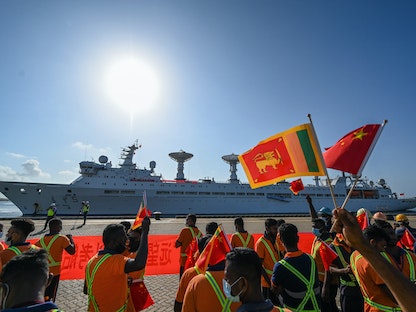 عمال يلوحون بالأعلام الوطنية للصين وسريلانكا عند وصول سفينة البحث والمسح الصينية (يوان وانج 5) في ميناء هامبانتوتا بسريلانكا، 16 أغسطس 2022 - AFP